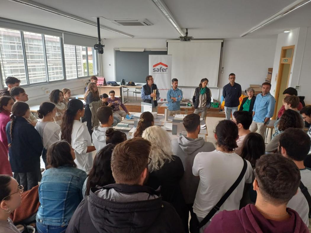 Alumnado, profesores y profesionales reunidos en torno a materiales y piezas de construcción.