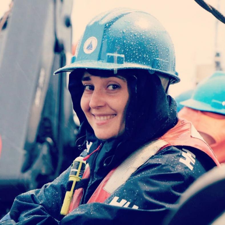 Primer plano de Elena Ceballos con traje de seguridad para su investigación. Casco azul y chaleco salvavidas naranja.