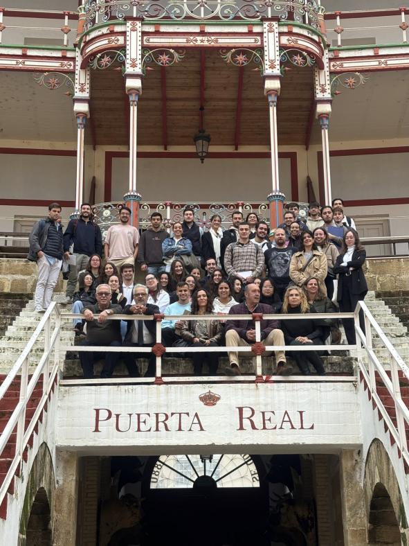 Fotografía del grupo de estudiantes y profesorado sentados en el palco de la Puerta Real.