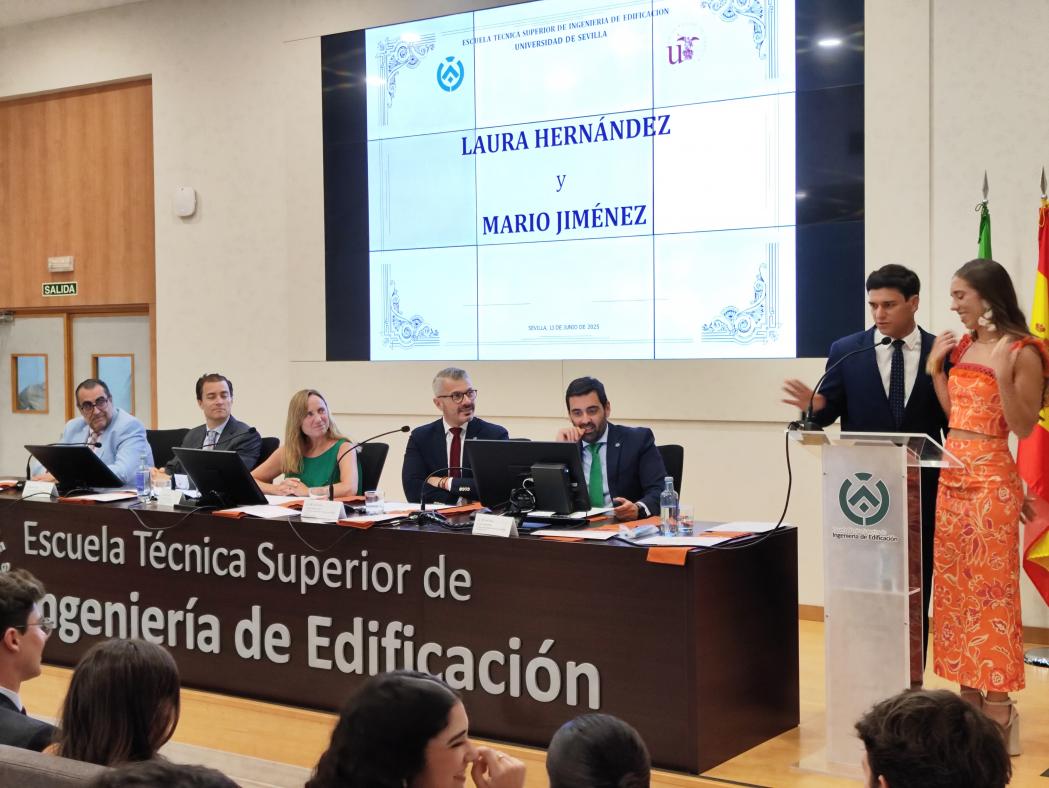 Fotografía del evento donde se ve la mesa presidencial con la Directora y subdirectores de la ETSIE, junto a un alumno y alumna presentando el acto.