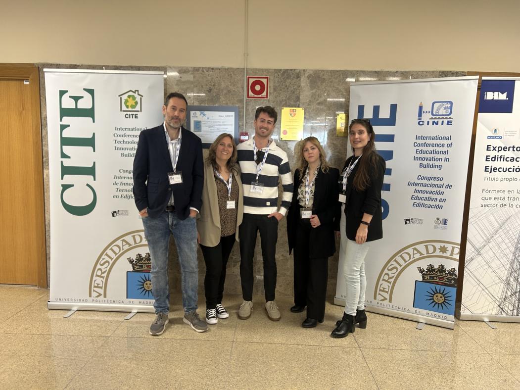 Profesorado asistente junto a los carteles de los congresos CITE y CINIE