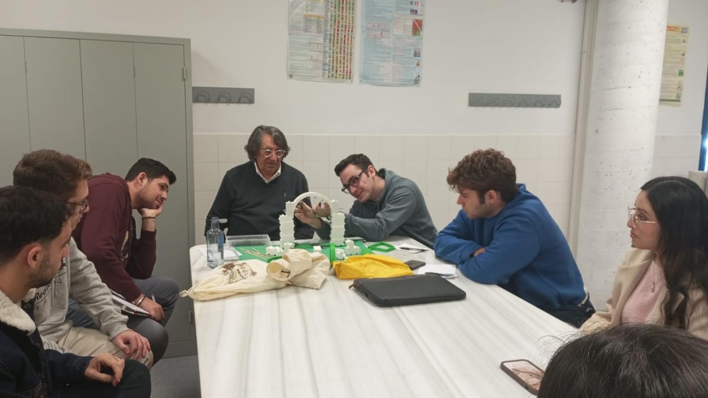 Fotografía de D. Manuel Fortea con el alunado en el laboratorio. Un alumno monta una maqueta de un arco de dovelas.