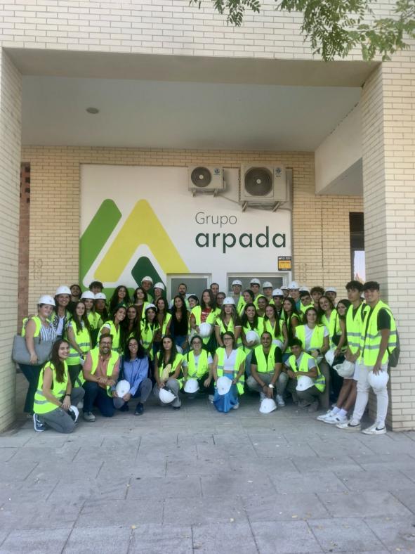 Grupo de estudiantes con el cartel de Grupo Arpada de fondo.